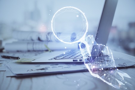 Ein Computer und eine digital gezeichnete Hand symbolisieren Forschung und Lehre