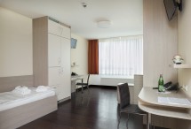 Zimmer für Patientinnen und Patienten auf der Komfortstation des LVR-Klinikum Essen mit Bett und Schreibtisch